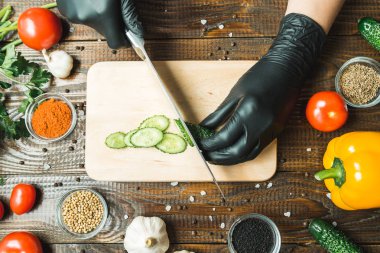 kadınların elleri bir salatalık, domates, kırmızı biber ve sarımsak yakın kesme