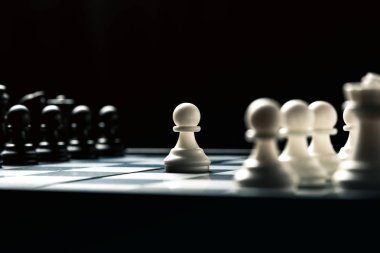 Siyah ve beyaz satranç birbirilerine bakan ile satranç masası. Beyaz piyon saldırı gider. Yatay çerçeve