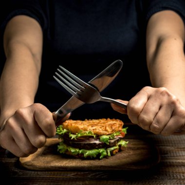 Sağlıklı yaşam, doğru beslenme. Sağlıklı pirinç burger sebzeler, otlar ve pirzola ahşap tahta üzerinde eller gösteri yasak. Yatay çerçeve