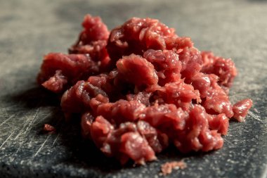 ince kıyılmış kırmızı et ahşap bir gemide. Yatay çerçeve