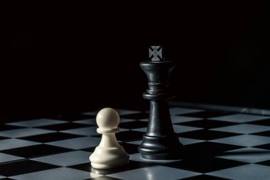 Chess board. Black king threatens white opponent's pawn. Horizontal frame clipart