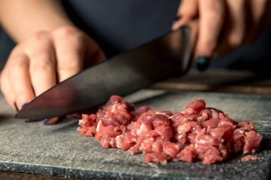 Şef eller bir gemide kırmızı eti kesip. Yatay çerçeve