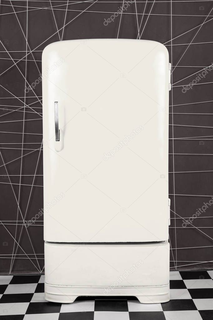 old vintage white refrigerator on a deep background. Vertical frame