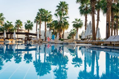 Otelin eğlence için iç. Mavi su havuzu, palmiye ağaçları ve güneşlenme yatakları