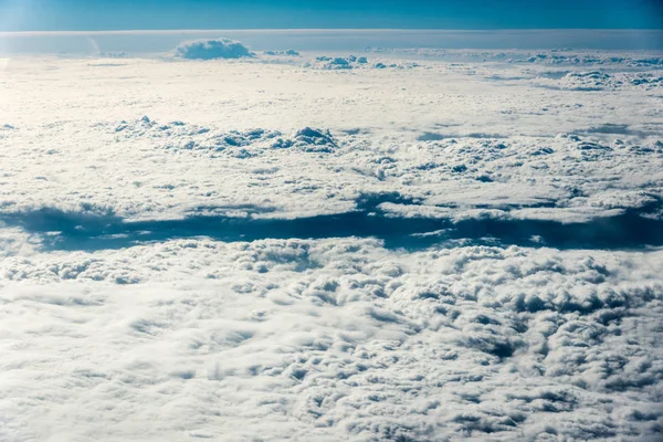 Вид сверху на белые облака над землей или водой — стоковое фото