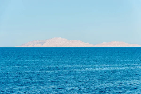 Rocky island in the distance over the beautiful blue sea — Stock Photo, Image