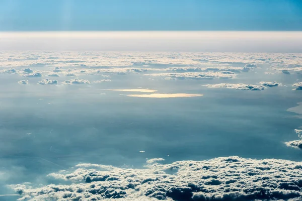 Pohled shora bílé mraky nad zemí nebo vodou — Stock fotografie