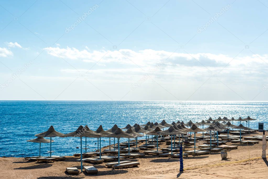Travel and recreation, sun umbrellas, sun beds on the background of the blue sea
