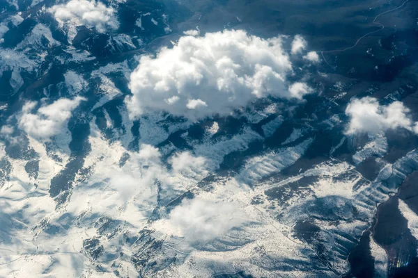 Top view of white clouds between which you can see high mountains — Stock Photo, Image