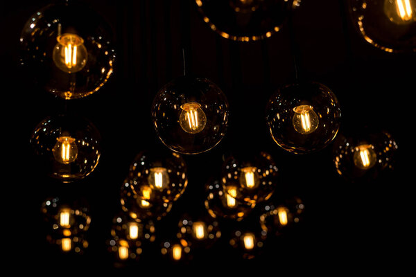 многие горящие лампы накаливания висят на потолке
