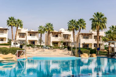 Sharm el-Sheikh, Mısır, 02/25/2019. Otelin eğlence için iç. Mavi su havuzu, palmiye ağaçları ve güneşlenme yatakları