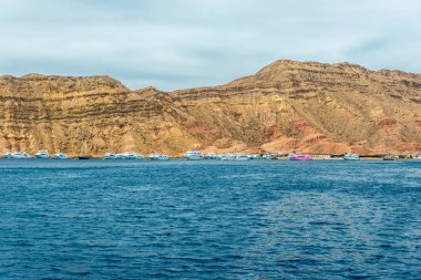 Deniz manzarası, arka planda yüksek kel Dağları ile mavi deniz görünümü