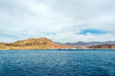 Deniz manzarası, arka planda yüksek kel Dağları ile mavi deniz görünümü