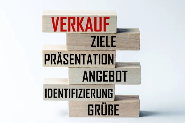 Lista drewnianych bloków leżących na szczycie siebie z listą technik sprzedaży w języku niemieckim. Rama pozioma — Zdjęcie stockowe
