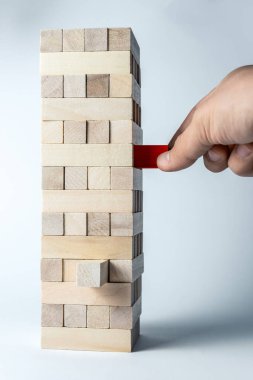 Erkek el, destek, takım çalışması ve iş geliştirme sembolü olarak, ahşap küpler kuleye bir küp koyar. Dikey çerçeve