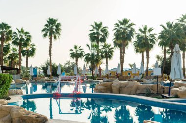 Sharm el-Sheikh, Mısır, 02/25/2019. Otelin eğlence için iç. Mavi su havuzu, palmiye ağaçları ve güneşlenme yatakları