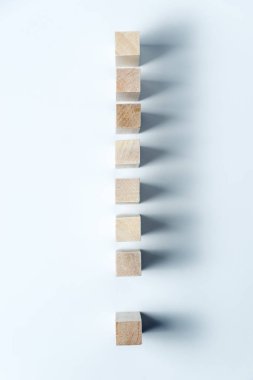 line of wooden cubes in the form of an exclamation mark. Vertical frame