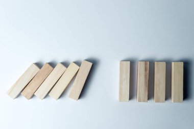 Düşen ahşap küpler, yenilgisembolü olarak, yanlış karar ve çöküş, düzensiz beyaz bir arka plan üzerinde. Yatay çerçeve
