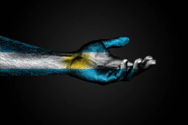 Mão estendida com uma bandeira da Argentina hasteada, um sinal de ajuda ou um pedido, em um fundo escuro — Fotografia de Stock