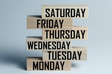 Altı günlük çalışma haftasının İngilizce günlerinin listesiyle üst üste yatan ahşap blokların listesi. Yatay çerçeve