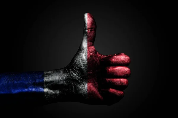 Een hand met een getekende Frankrijk vlag toont een vinger omhoog teken, een symbool van succes, gereedheid, een taak gedaan op een donkere achtergrond. — Stockfoto