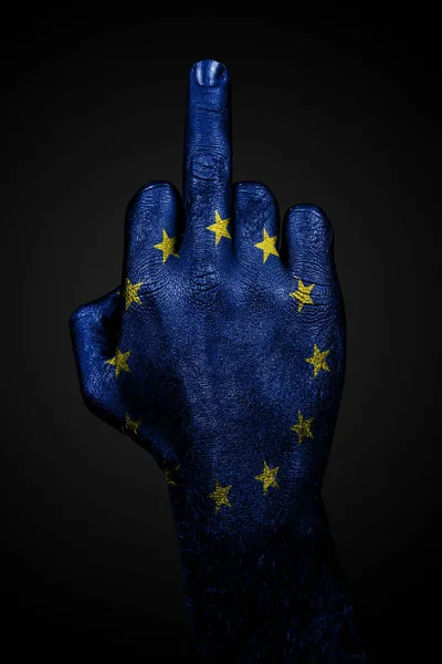 Una mano con una bandera de la UE dibujada muestra el dedo medio, un signo de agresión, sobre un fondo oscuro —  Fotos de Stock