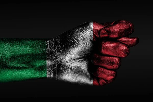 Eine Hand mit einer bemalten italienischen Flagge zeigt eine Feige, ein Zeichen von Aggression, Uneinigkeit, Streit auf dunklem Hintergrund. — Stockfoto