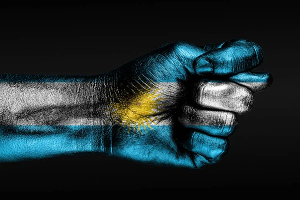 A hand with a painted Argentina flag shows a fig, a sign of aggression, disagreement, a dispute on a dark background. — Stock Photo, Image