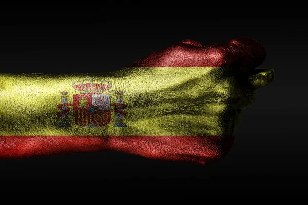 Ręka z pomalowaną flagą Hiszpanii pokazuje figę, oznakę agresji, brak porozumienia, spór na ciemnym tle. — Zdjęcie stockowe