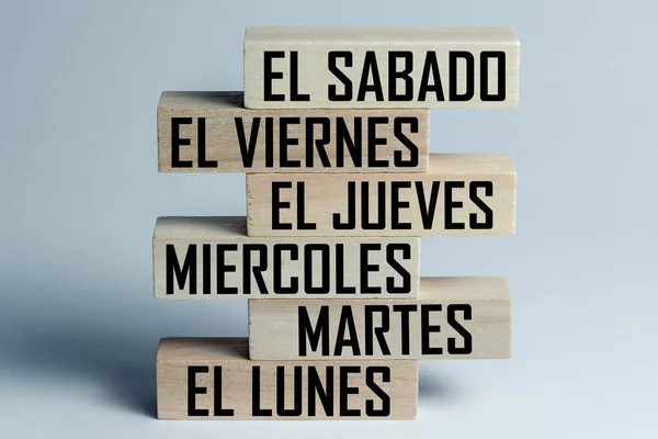 Список деревянных блоков, лежащих друг на друге со списком шестидневных рабочих дней на испанском языке. Горизонтальная рамка — стоковое фото