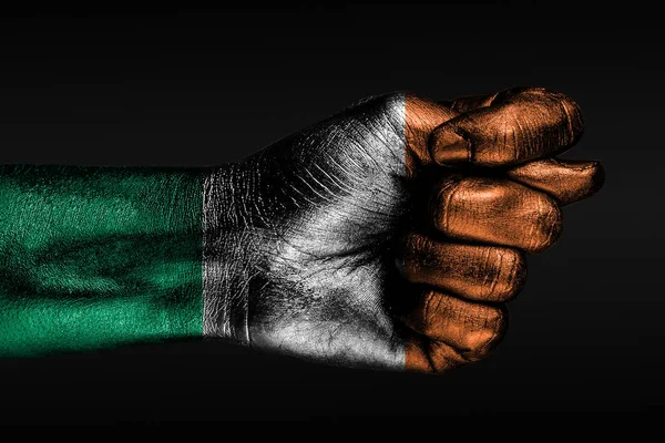 Una mano con una bandera de Irlanda pintada muestra un higo, un signo de agresión, desacuerdo, una disputa sobre un fondo oscuro . —  Fotos de Stock
