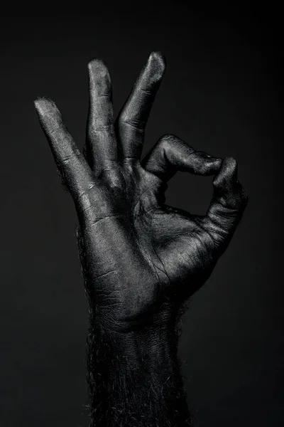 Рука повністю в чорній фарбі показує знак ОК — стокове фото