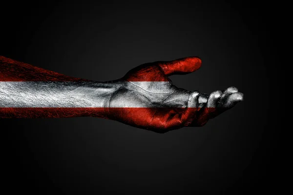 Протянутая рука с нарисованным флагом Австрии, знаком помощи или просьбой, на темном фоне . — стоковое фото