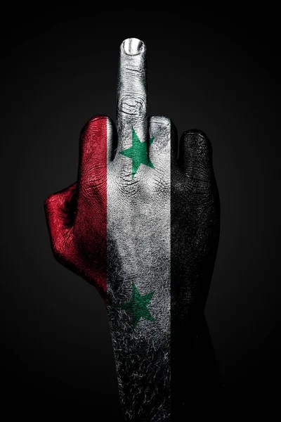 A hand with a painted flag of Syria shows the middle finger, a sign of aggression, against a dark background. — Stock Photo, Image