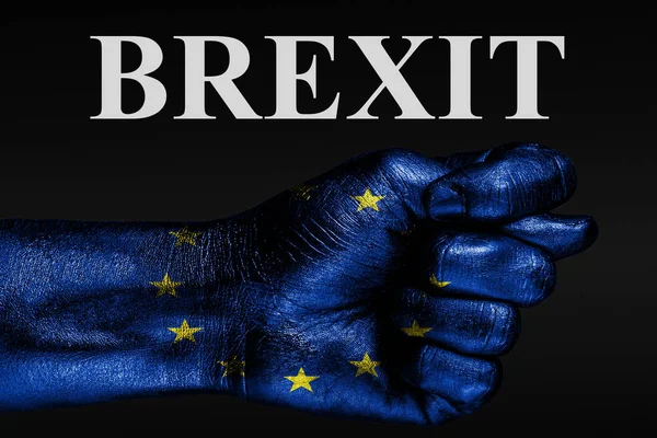 Auf einer Hand mit einer bemalten EU-Flagge befindet sich eine Feige und die Aufschrift "Brexit", ein Zeichen für Aggression, Uneinigkeit, Streit auf dunklem Hintergrund. — Stockfoto