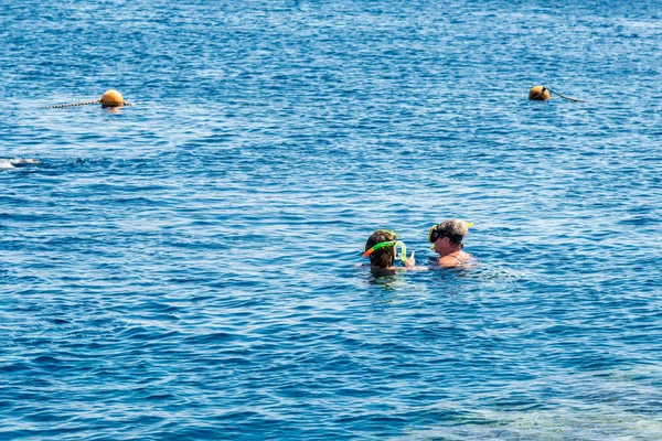 Utazás és szabadidő, emberek úszni a gyönyörű kék tenger — Stock Fotó