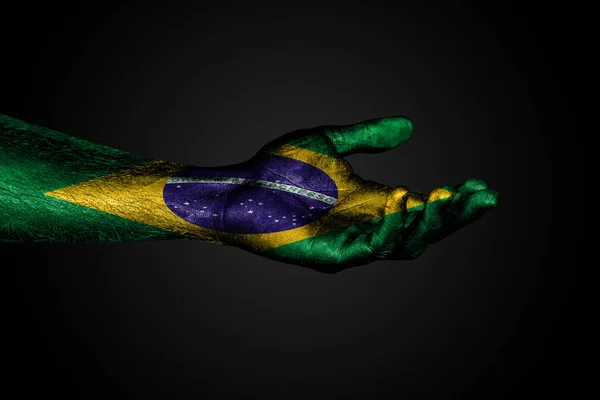 Outstretched hand with a drawn Brazil flag, a sign of help or a request, on a dark background. — Stock Photo, Image