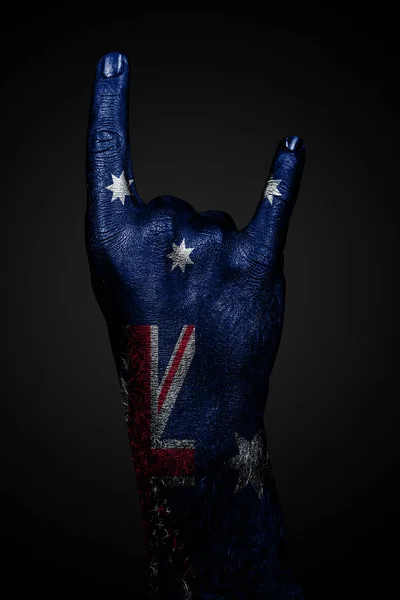 A hand with a drawn Australia flag shows a goat sign on a dark background. — Stock Photo, Image