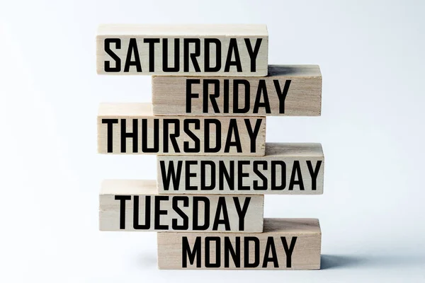 Список деревянных блоков, лежащих друг на друге, со списком дней шестидневной рабочей недели на английском языке. Горизонтальная рамка — стоковое фото