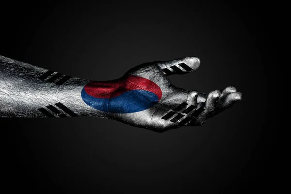 Mano extendida con una bandera de Corea del Sur dibujada, un signo de ayuda o una petición, sobre un fondo oscuro — Foto de Stock