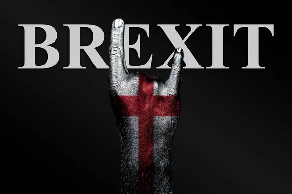 På en mørk bakgrunn viser en hånd med Englands malte flagg og ordet BREXIT et geitetegn, et symbol på mainstream, metall og rockemusikk. . – stockfoto