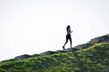 Koyu saçlı ince güzel kız merdivenlerden yukarı çalışır, sağlıklı yaşam tarzı sembolü, güçlü bir lider ve sağlıklı rekabet