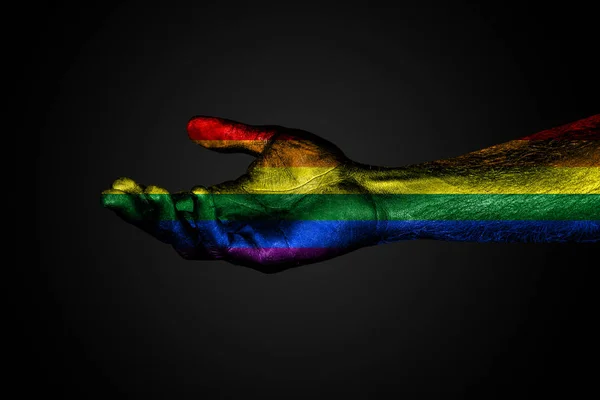 Una mano extendida con una bandera arcoíris pintada, un signo de ayuda o una petición, apoyo o pobreza, sobre un fondo oscuro —  Fotos de Stock