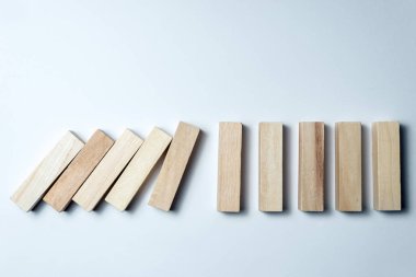 Düşen ahşap küpler, yenilgisembolü olarak, yanlış karar ve çöküş, düzensiz beyaz bir arka plan üzerinde. Yatay çerçeve