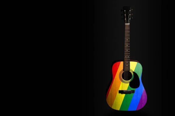 Acoustic concert guitar with a drawn flag rainbow, on a dark background, as a symbol of national creativity or folk song. — Stock Photo, Image