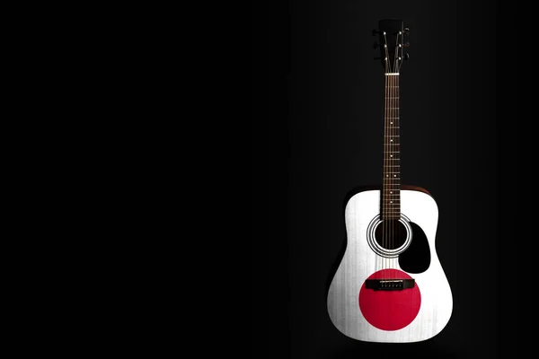 Acoustic concert guitar with a drawn flag Japan, on a dark background, as a symbol of national creativity or folk song. — Stock Photo, Image