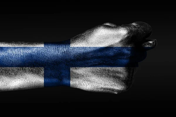 塗装されたフィンランドの旗を持つ手は、イチジク、侵略の兆候、意見の相違、暗い背景の紛争を示しています. — ストック写真