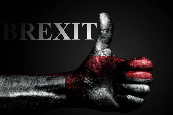 A hand with a painted flag of England shows a thumbs up sign and the inscription BREXIT, a symbol of success, readiness, and a task performed on a dark background. — Stock Photo, Image