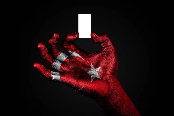 Main avec un drapeau peint Turquie tenant une petite feuille blanche avec de l'espace pour une inscription, maquette — Photo