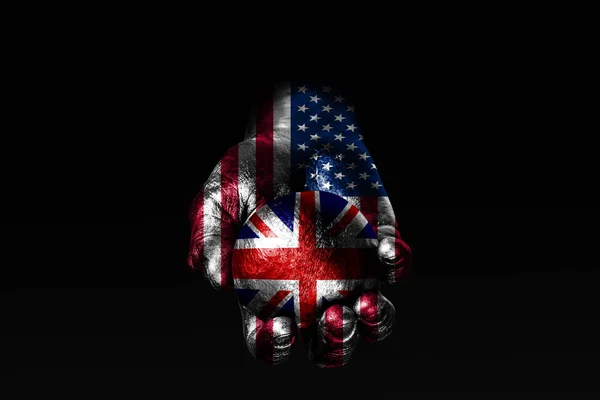 Una mano con una bandera estadounidense dibujada sostiene una pelota con una bandera británica dibujada, un signo de influencia, presión o conservación y protección . —  Fotos de Stock
